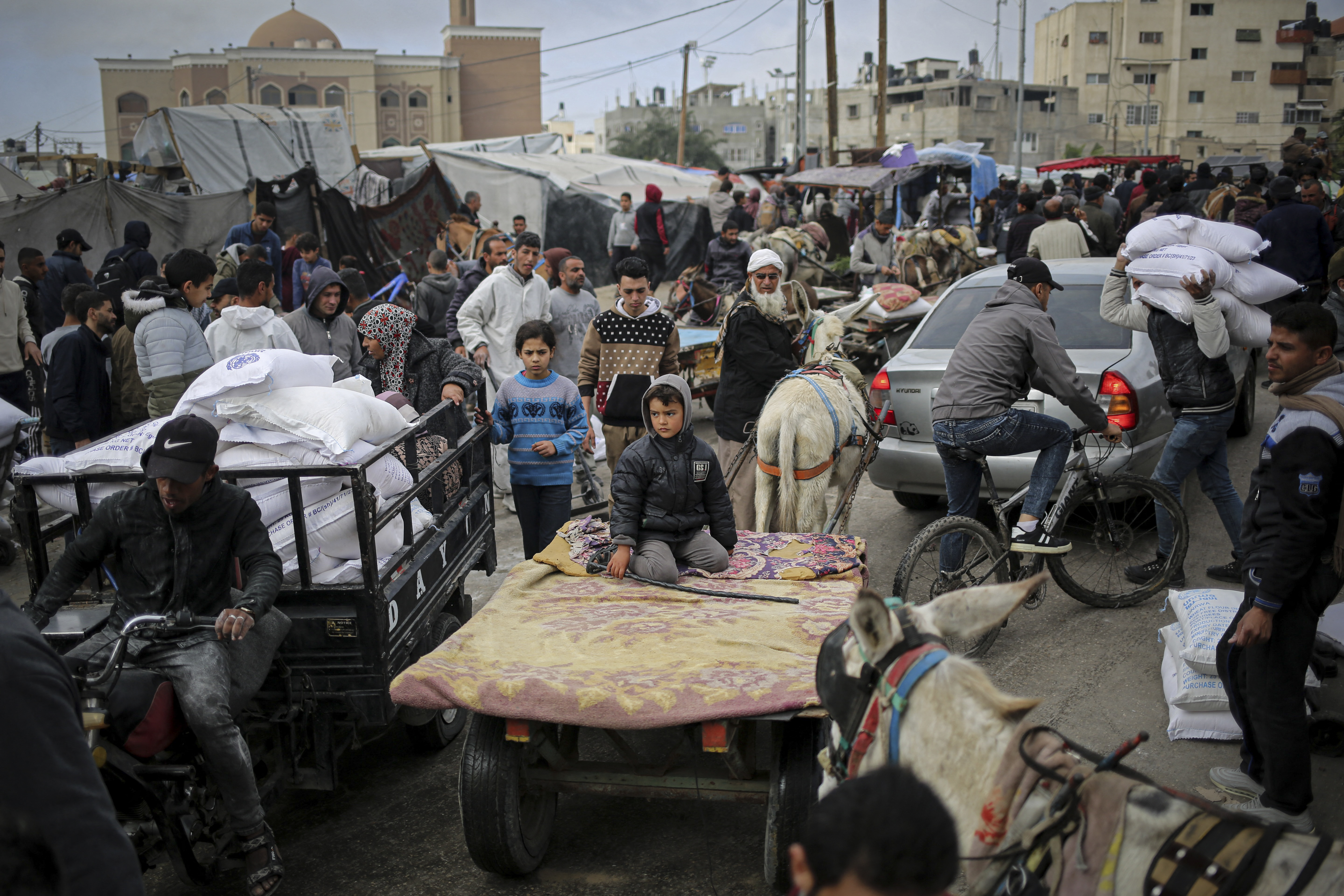 A Palestinian man transports sacks of humanitarian aid in a vehicle outside the distribution center of the United Nations Relief and Works Agency for Palestine Refugees (UNRWA), in Rafah in the southern Gaza Strip on March 3, 2024, amid the ongoing conflict between Israel and the Hamas movement. (Photo by AFP)