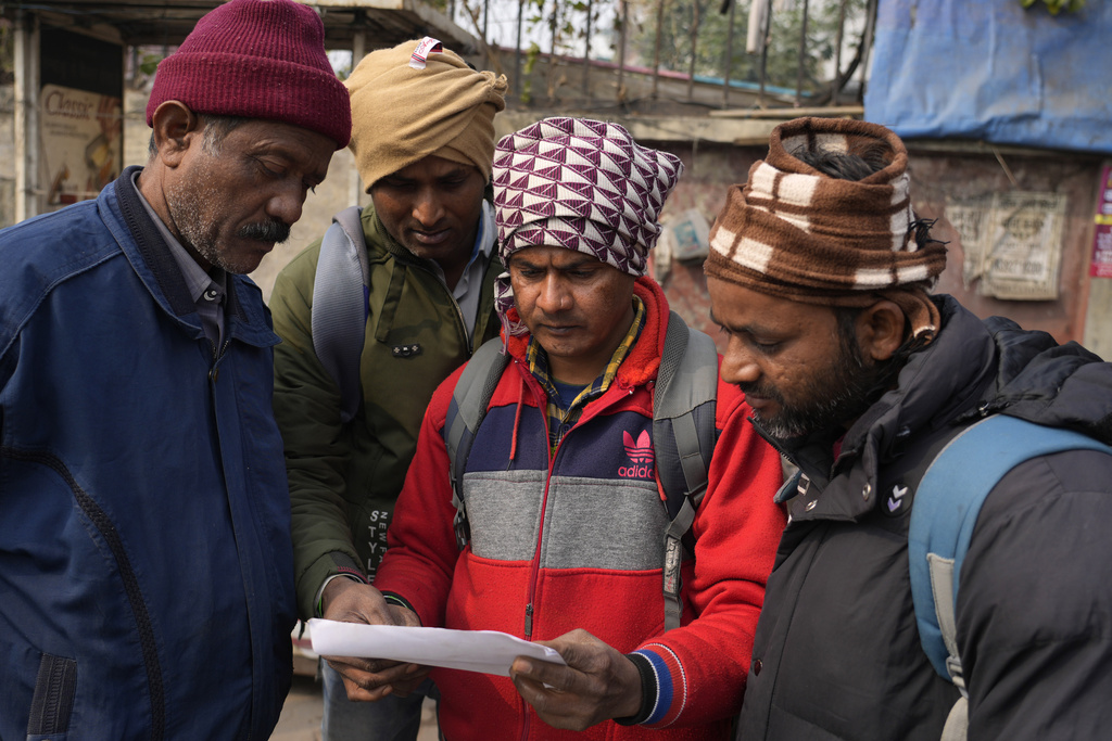 Indian workers aspiring to be hired for jobs in Israel look at a form that needs to be filled during a recruitment drive in Lucknow, India
