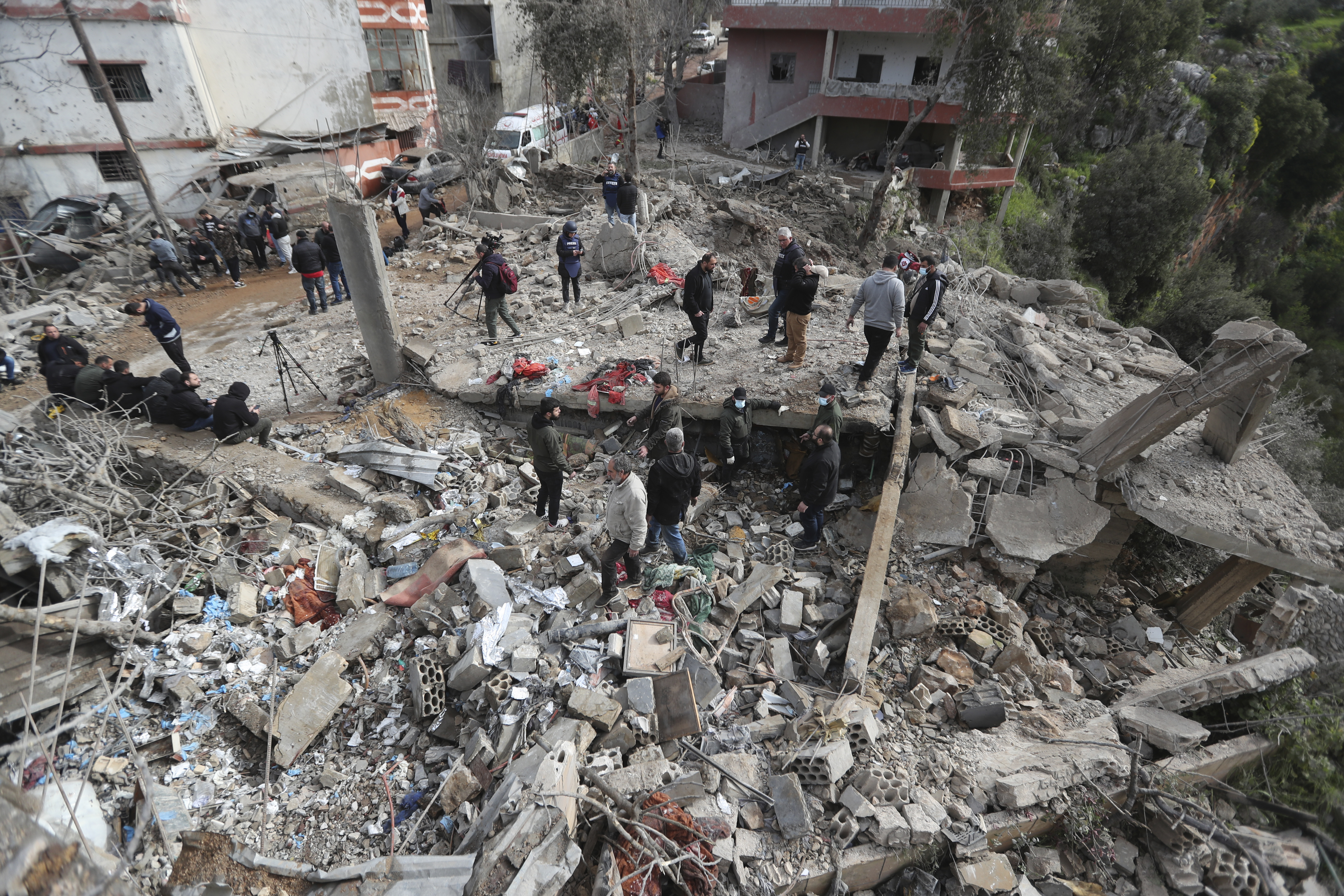 People gather on the rubble of a paramedic center that was destroyed by an Israeli airstrike in Hebbariye village, southern Lebanon [Mohammed Zaatari/AP Photo]