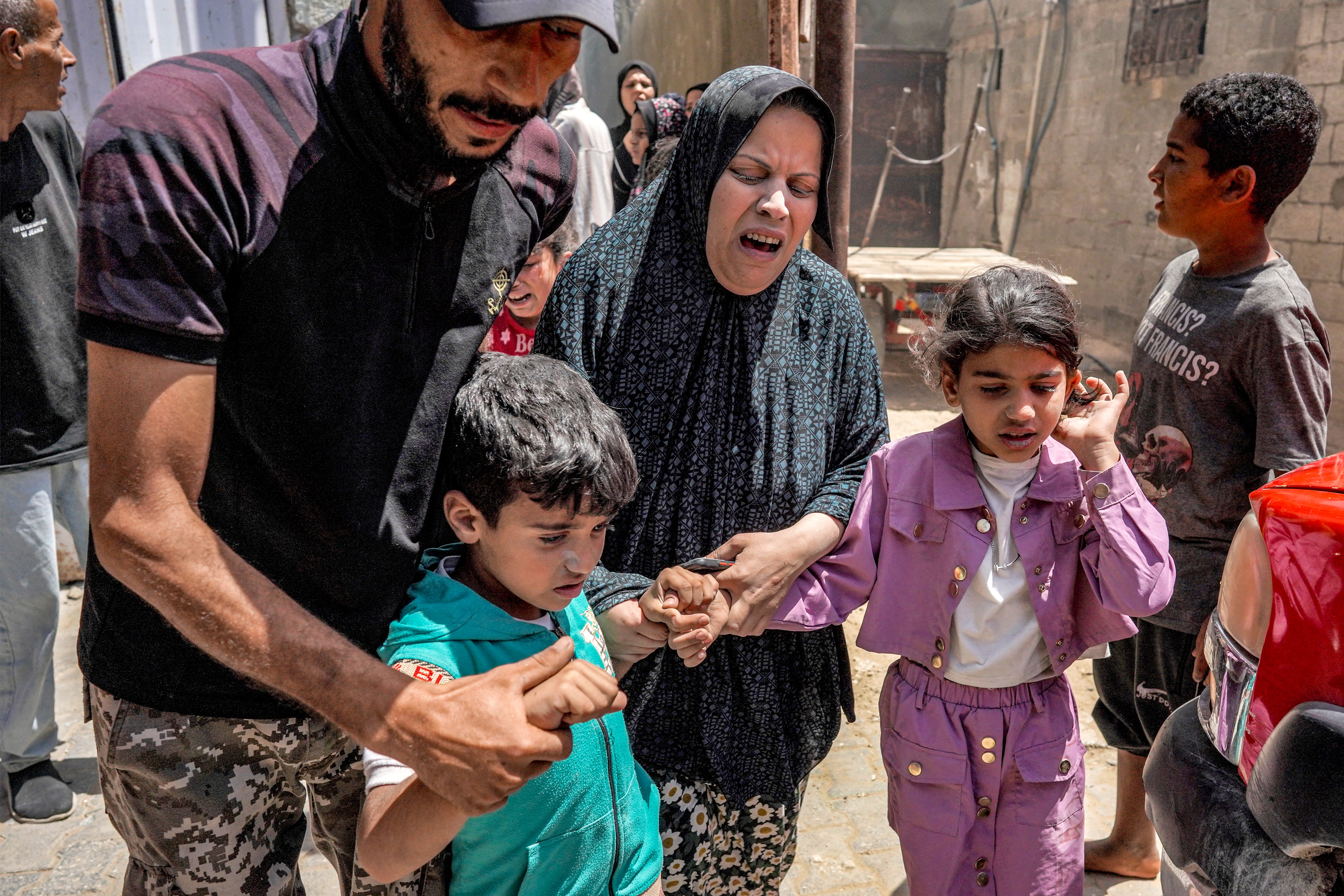 A woman and children react as they flee following Israeli bombardment in Nuseirat in the central Gaza Strip