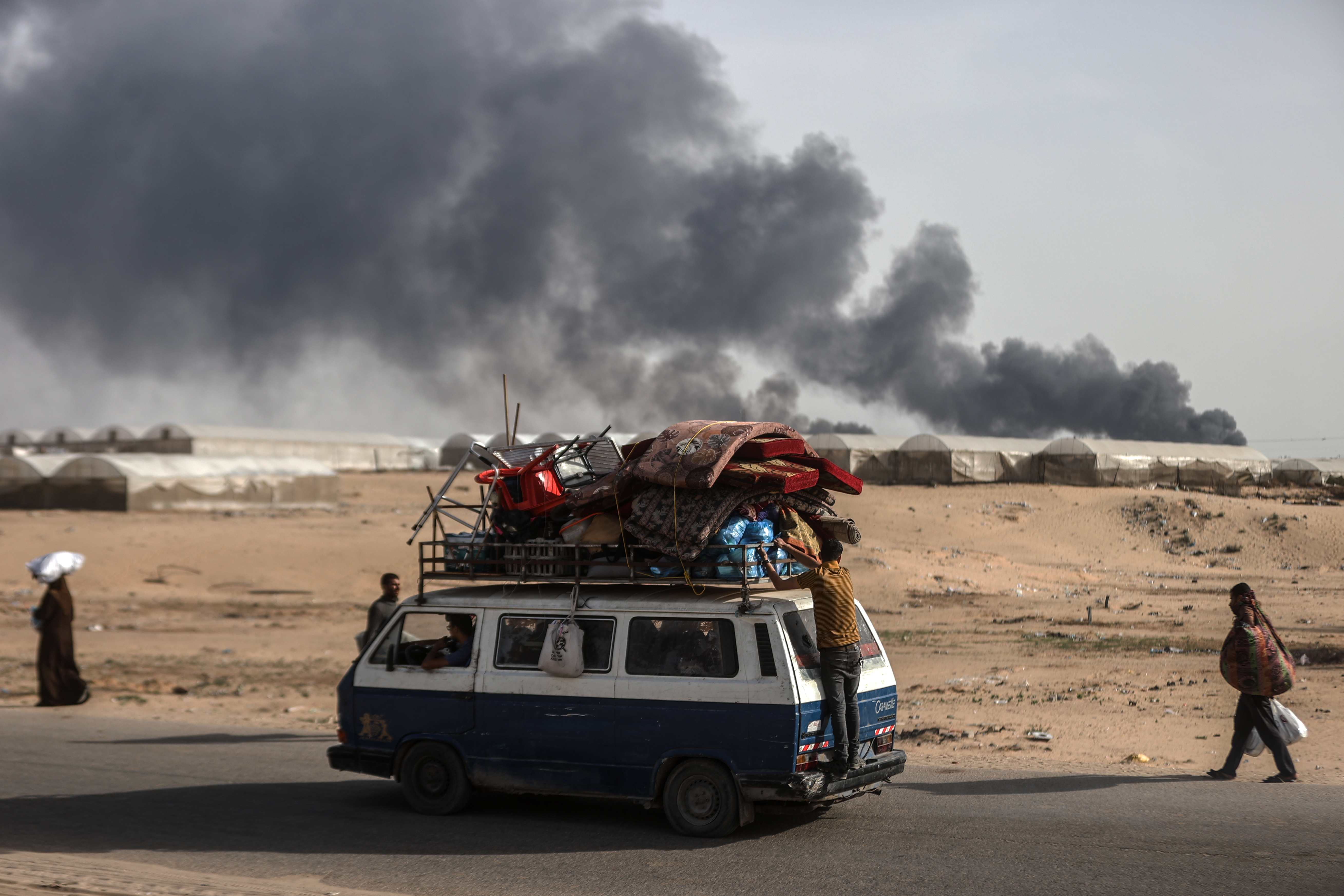Palestinians, carrying their personal belongings with them, migrate to the areas where they consider as a safe after the Israeli army targeted tents in Al-Mawasi